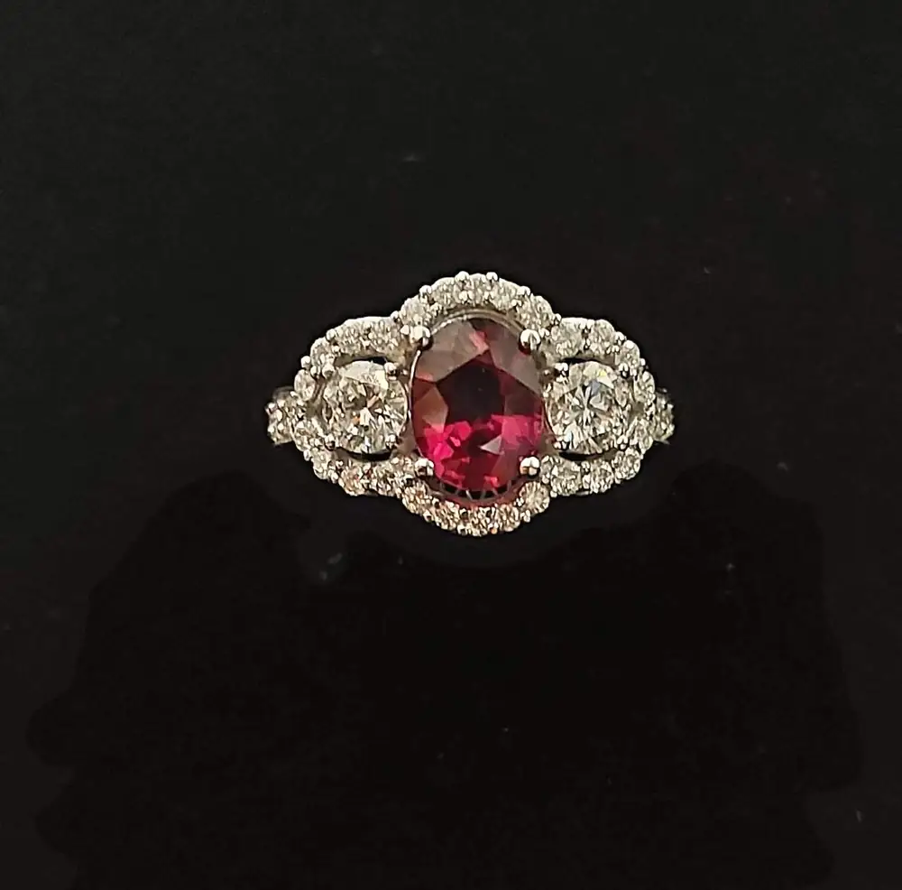 Anello con pietra rossa ovale, due brillanti e contorno di diamanti, realizzato da Geri Gioielli