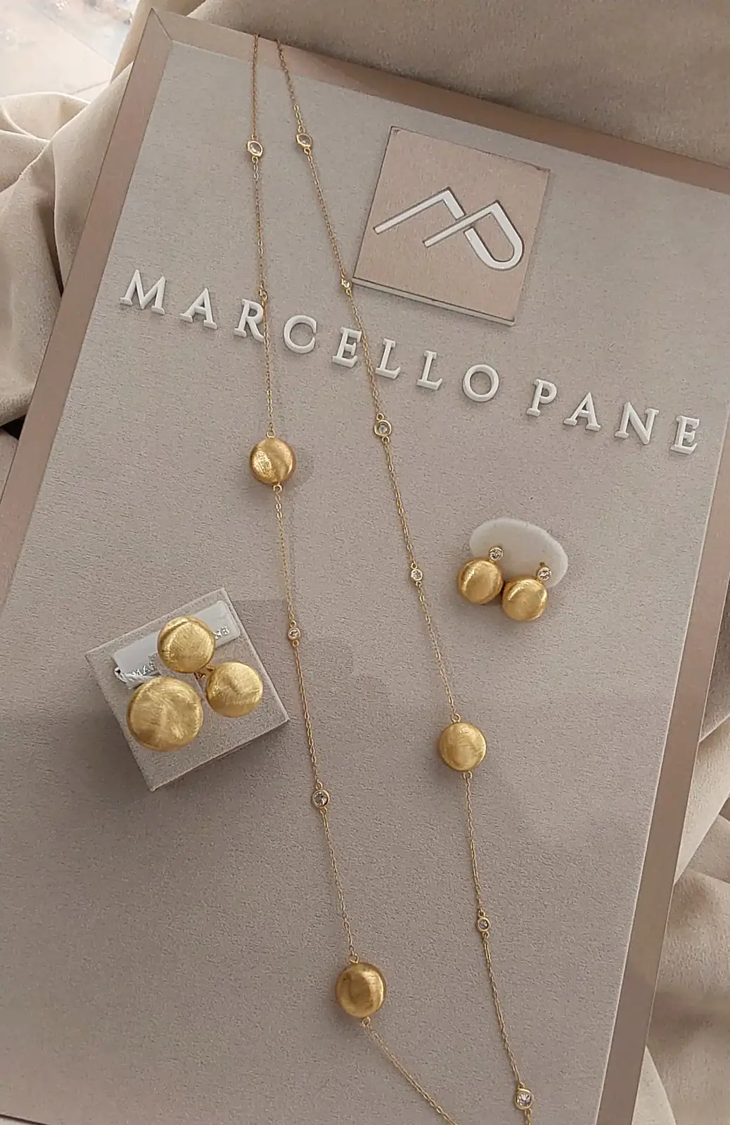Collana, anello e orecchini Marcello Pane in oro satinato